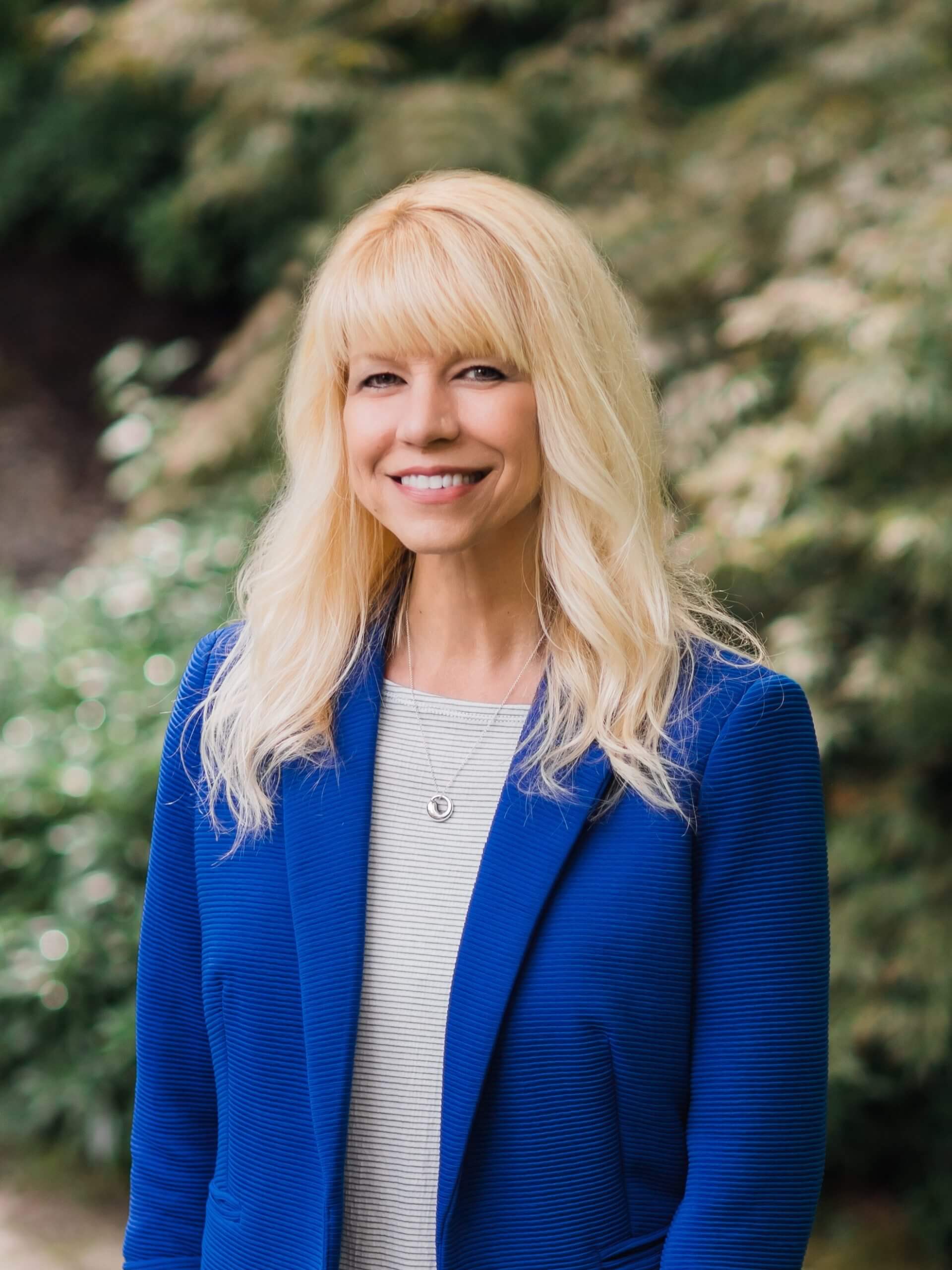 A woman with blonde hair and blue jacket.